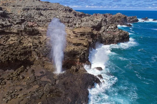 The Halona Blowhole shooting spray above a dark lava shelf